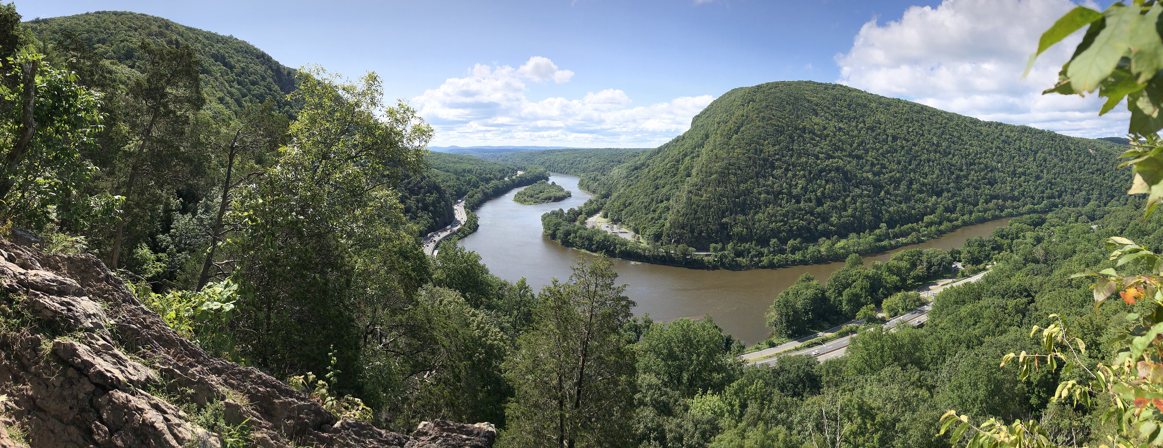 Panoramic view from the Mount Tammany Trail of the Delaware River cutting between two forested ridges, with Interstate 80 running along the far shore