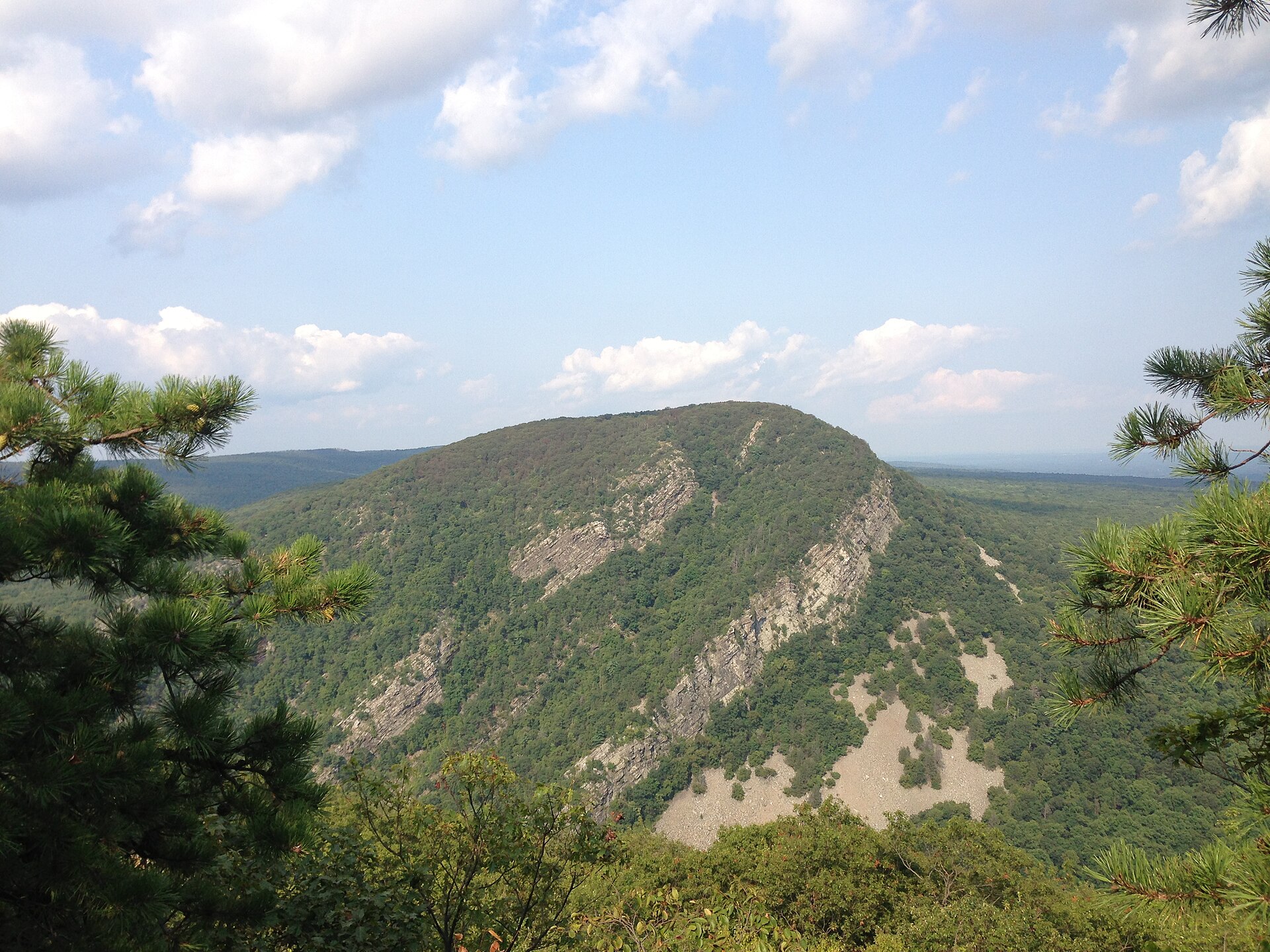 Mount Tammany seen across the Delaware Water Gap, a rounded forested summit with grey cliff bands and a pale scree slope below it
